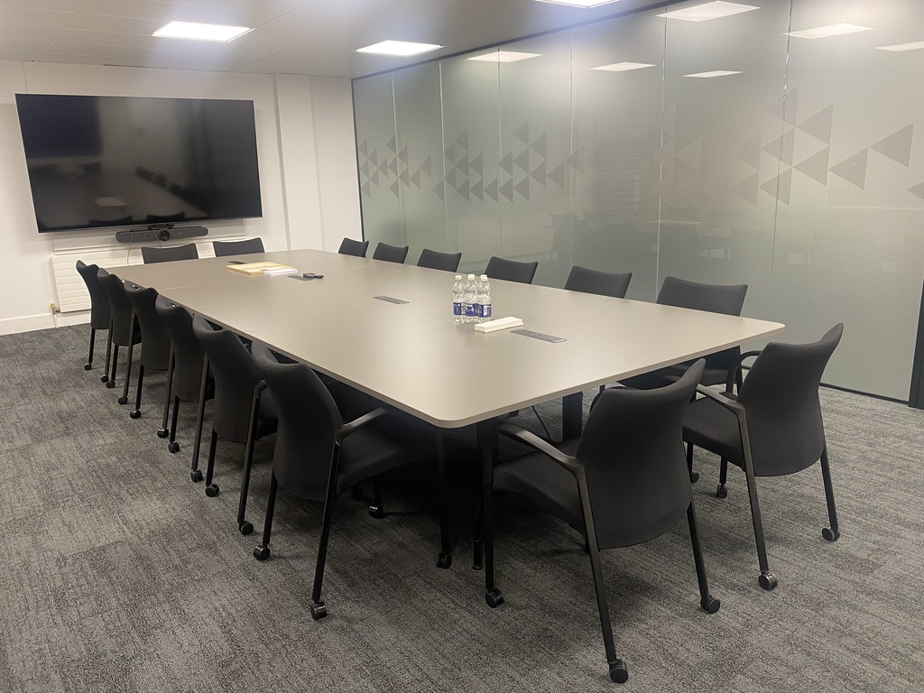 Office boardroom with a long meeting table and glass partitions