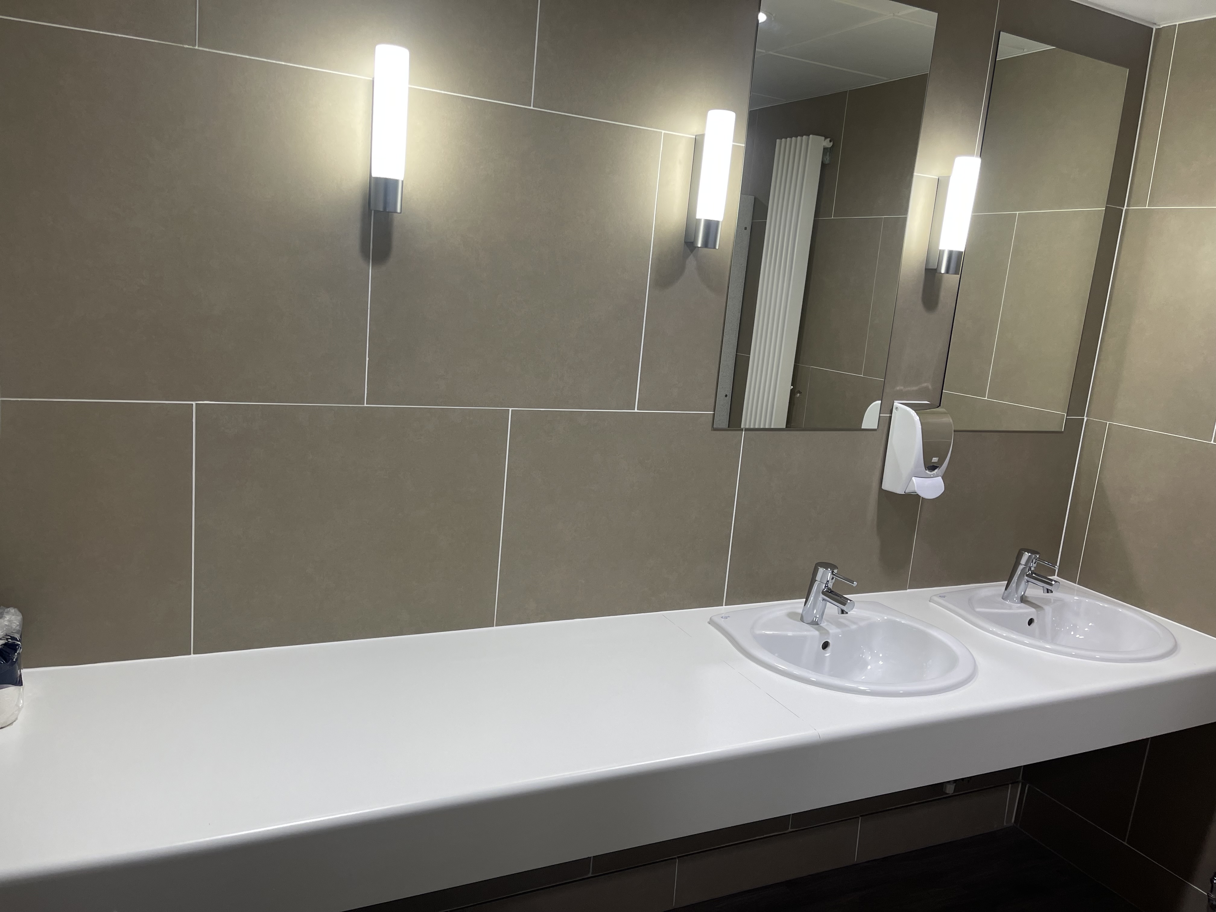 Clean modern commercial washroom sinks and mirrors
